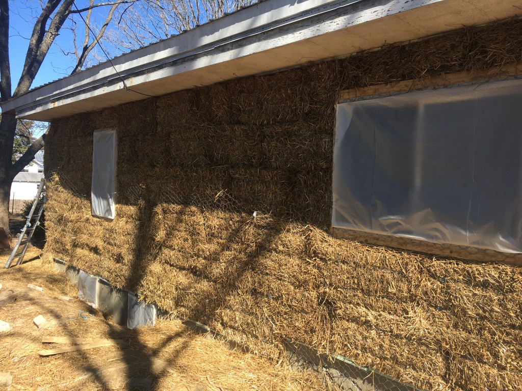 Wall of house wrapped in strawbales
