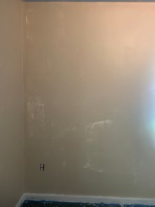 Photo of wall with very rough and patchy coat of paint